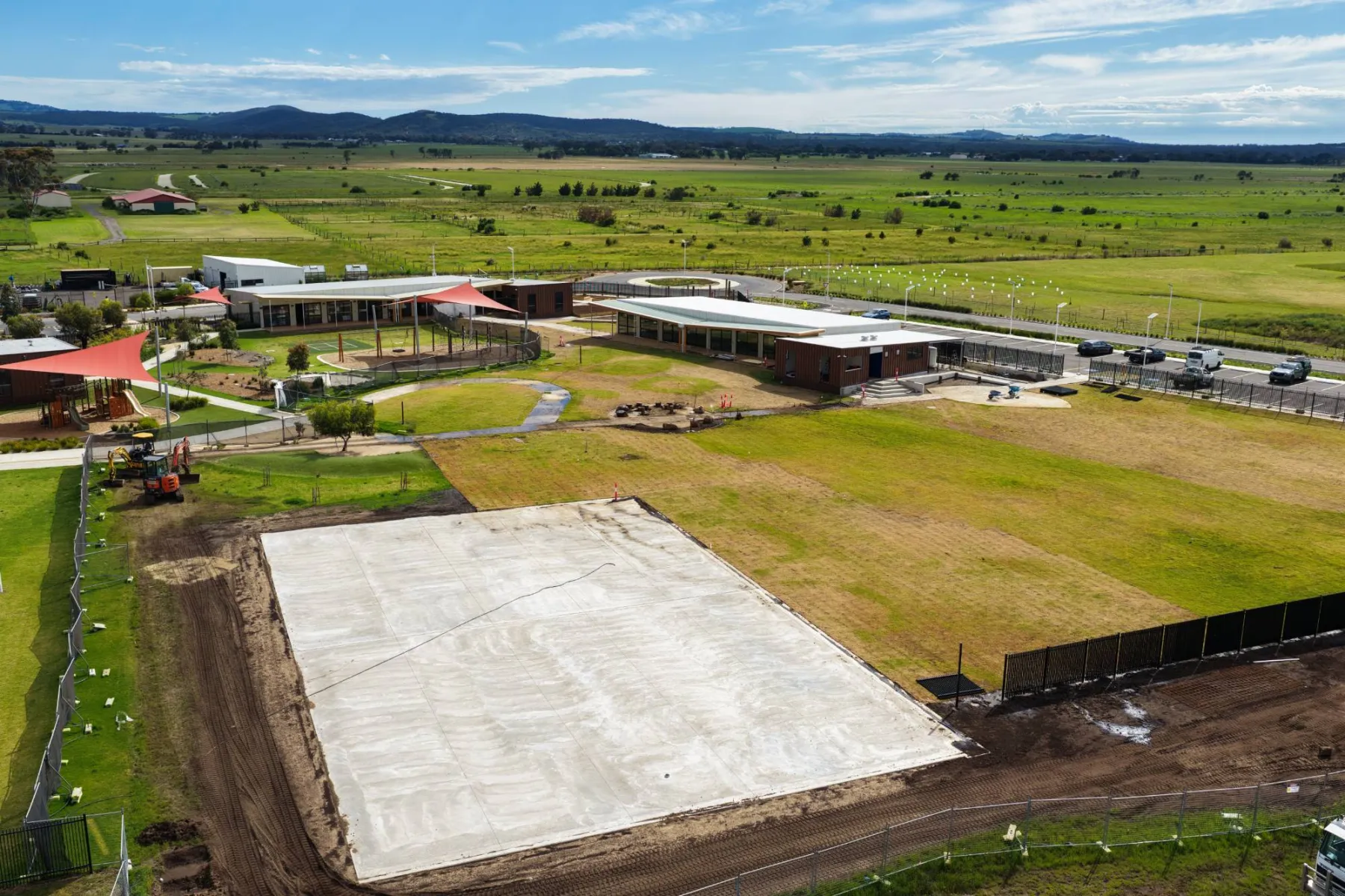 The campus from the turfed end, looking across the new building and shade sails to the hills in the distance